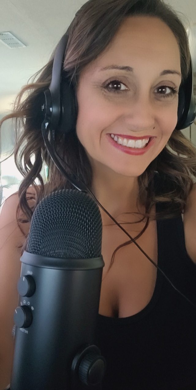 Janell recording her live podcast, wearing headphones at a studio microphone